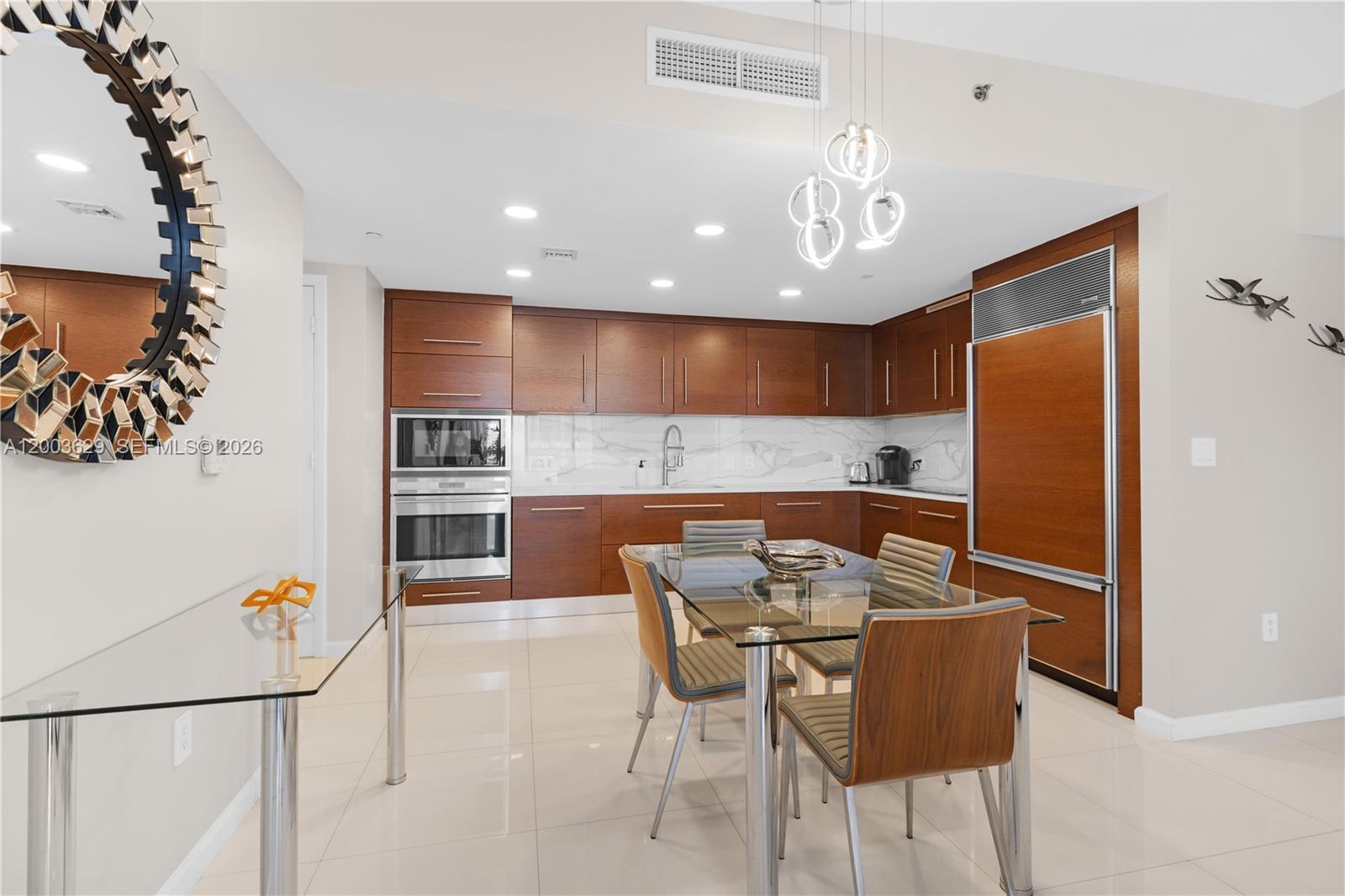 485 Brickell Avenue, Unit 4501 Miami, FL 33131 - Photo 10 of 49 a kitchen with stainless steel appliances kitchen island granite countertop a refrigerator a stove and a dining table with wooden floor