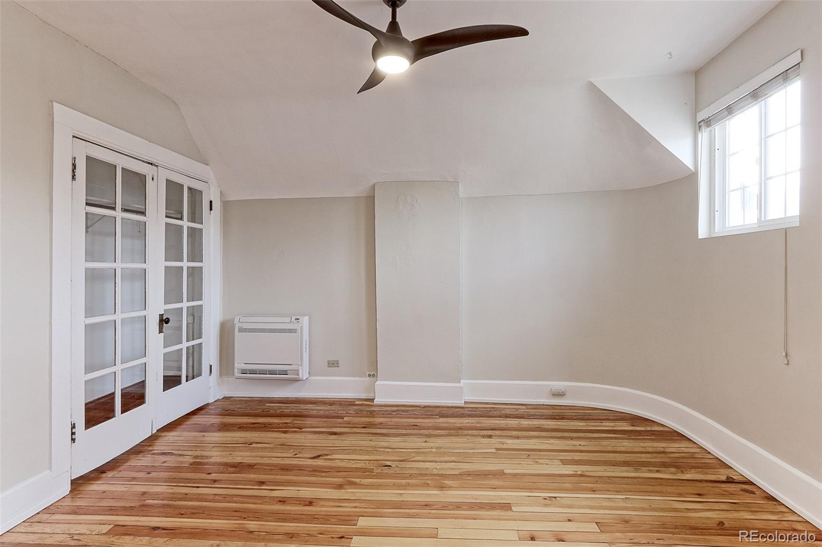 4576 Stuart Street Denver, CO 80212 - Photo 25 of 43 a view of an empty room with a window and wooden floor
