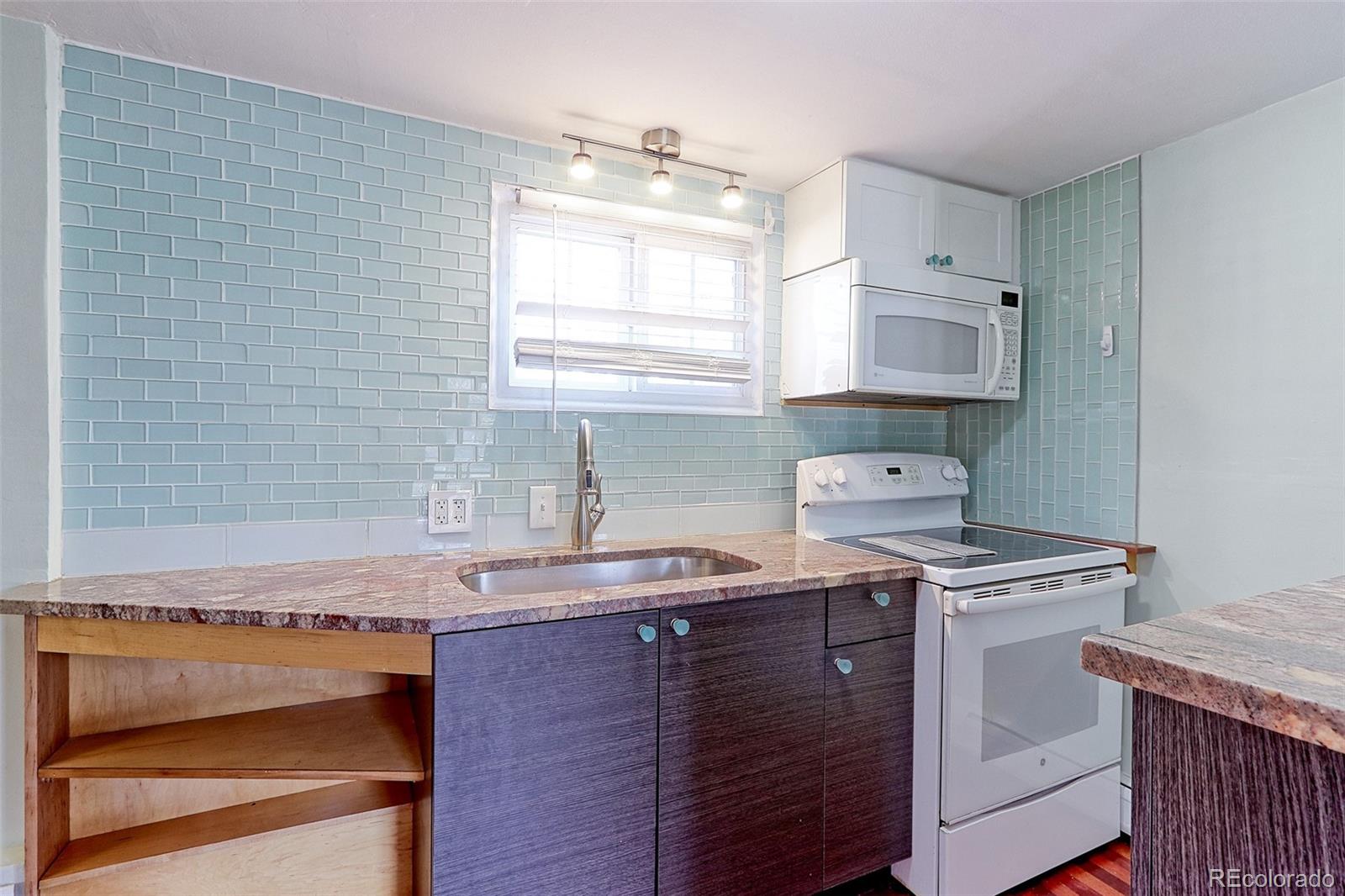 4576 Stuart Street Denver, CO 80212 - Photo 34 of 43 a kitchen with granite countertop a sink a stove and cabinets