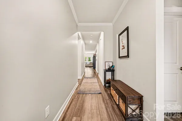 a view of a hallway with wooden floor and staircase