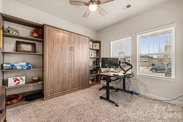 a view of a workspace with furniture and a window