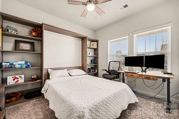 a bedroom with a bed window and a flat screen tv