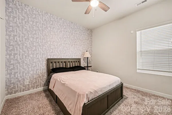 a bed sitting in a bedroom next to a window