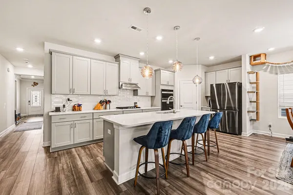 a kitchen with stainless steel appliances kitchen island granite countertop a refrigerator and a stove top oven