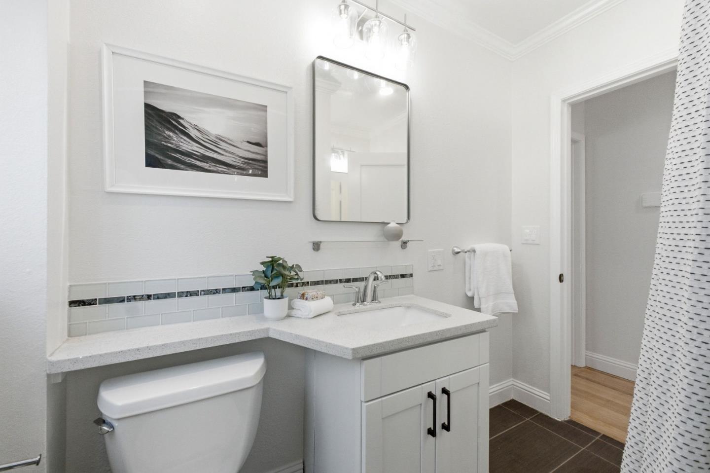 9858 Golf Links Road Oakland, CA 94605 - Photo 23 of 39 a bathroom with a toilet sink and mirror