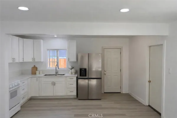 a kitchen with a refrigerator sink and cabinets