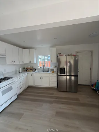 a large kitchen with white cabinets and stainless steel appliances