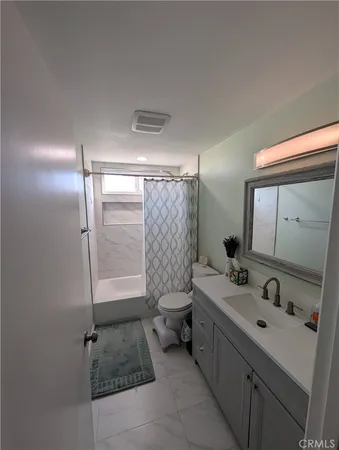 a bathroom with a double vanity sink toilet and shower