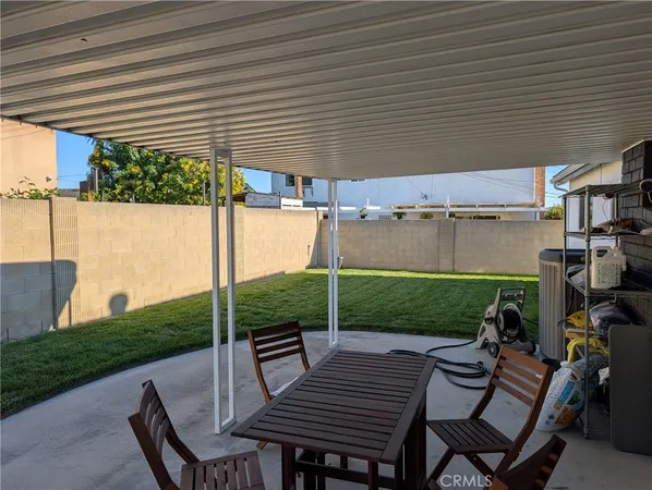 a view of a patio with table and chairs with wooden floor and fence