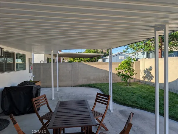 a view of a patio with table and chairs with wooden floor and floor to ceiling window