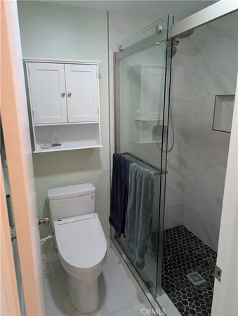a bathroom with a toilet and a shower