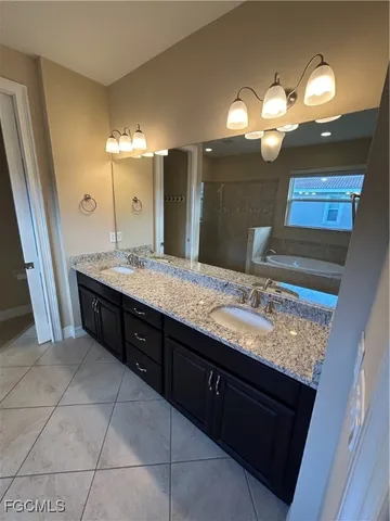 a bathroom with a granite countertop sink a large mirror and a shower