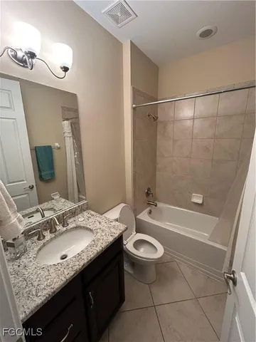 a bathroom with a granite countertop sink a toilet a mirror and shower