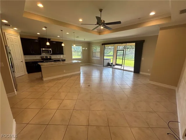 a view of a living room with stainless steel appliances with kitchen view