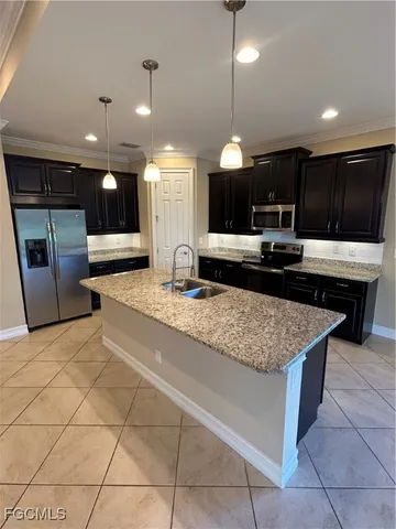 a large kitchen with a large counter top and stainless steel appliances