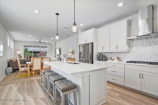 a large white kitchen with lots of counter space a sink appliances and cabinets