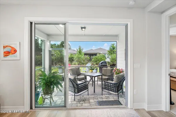 a dining room with furniture and a floor to ceiling window