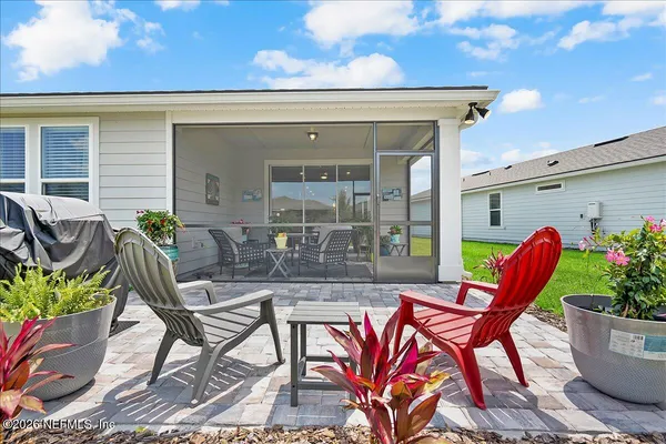 a view of a patio with table and chairs potted plants and a large tree