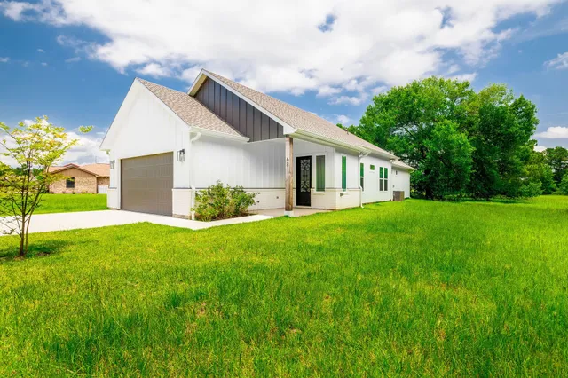 a front view of house with yard and green space