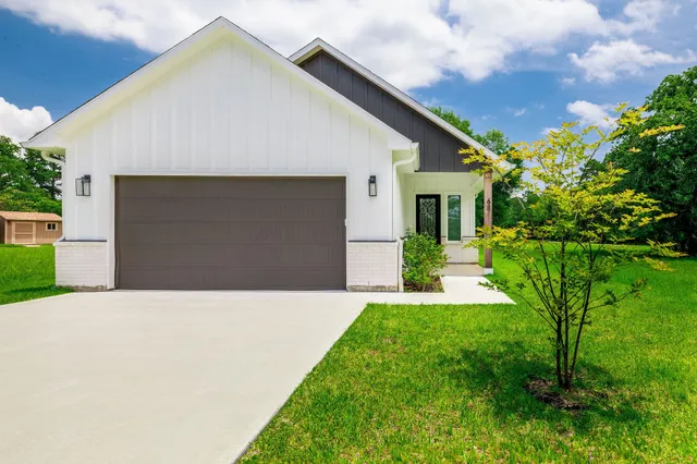 a front view of a house with a yard and potted plants