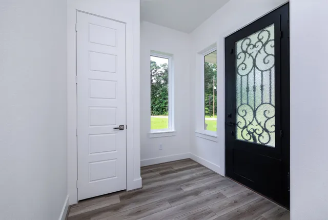 a view of a hallway with wooden floor and a ceiling fan