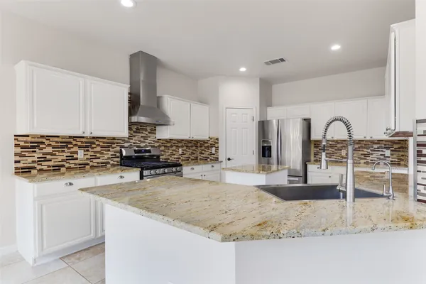 a kitchen with stainless steel appliances granite countertop a sink and a stove