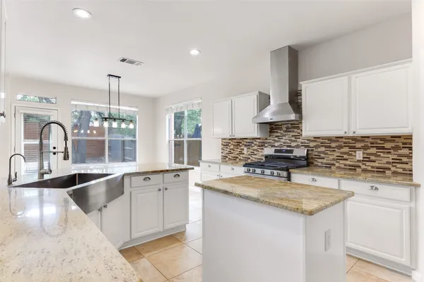 a kitchen with granite countertop a sink and a stove top oven