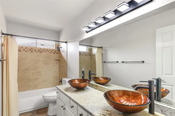 a bathroom with a granite countertop sink mirror toilet and bathtub