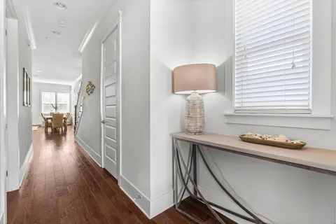 a hallway with white cabinets and wooden floor