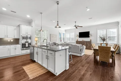 a large kitchen with cabinets a sink a window and stainless steel appliances