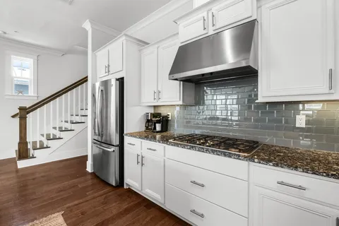 a kitchen with granite countertop a stove and a wooden floors