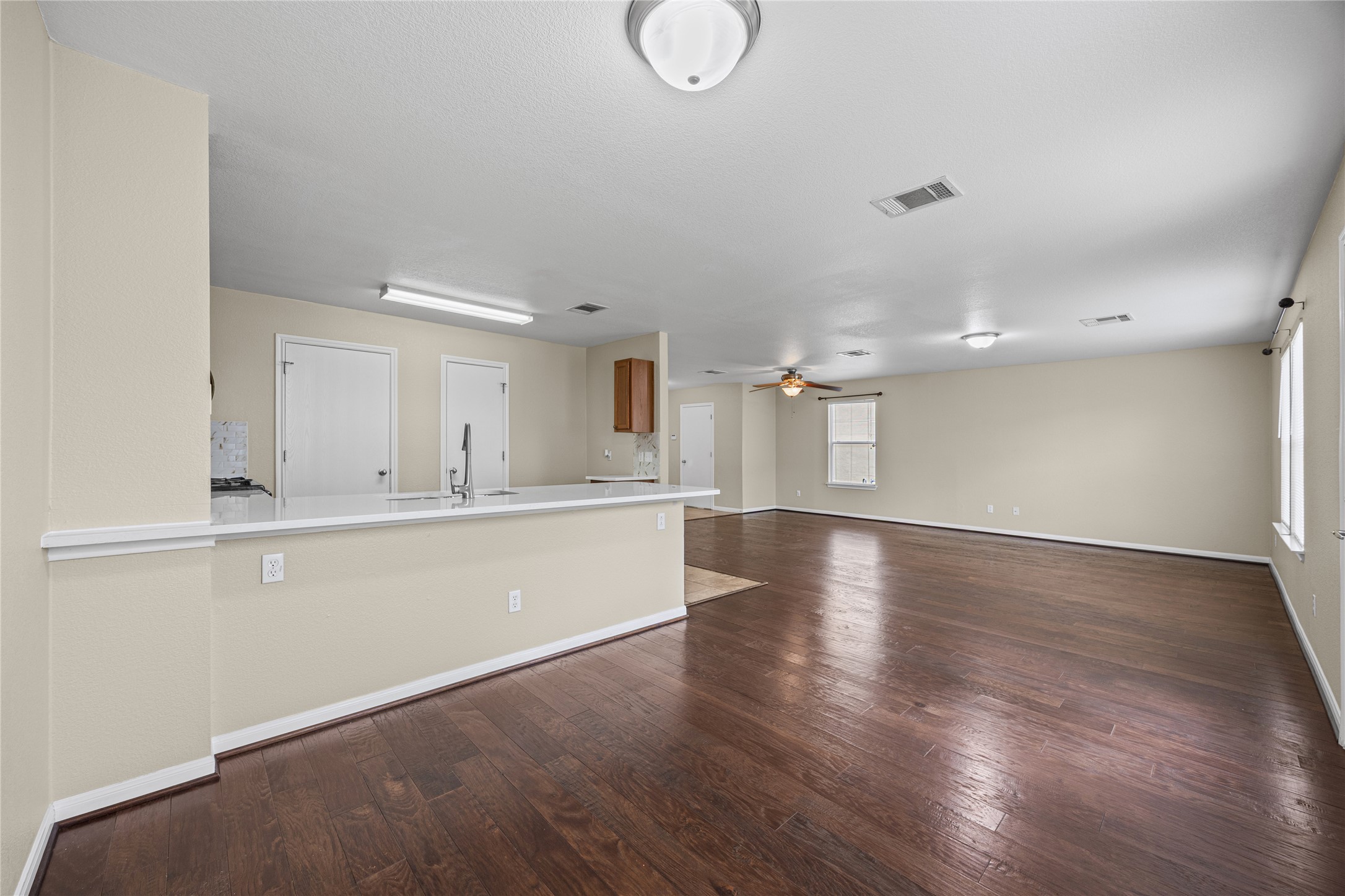 198 Black Forest Road Buda, TX 78610 - Photo 22 of 23 An open floorplan seamlessly connects the kitchen with a spacious living area, highlighted by gleaming wood floors.