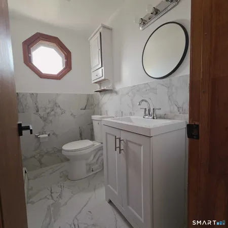 a bathroom with a toilet sink and mirror