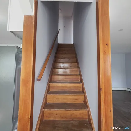 a view of staircase with wooden floor and white walls