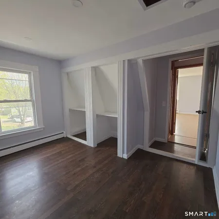 an empty room with wooden floor and a window