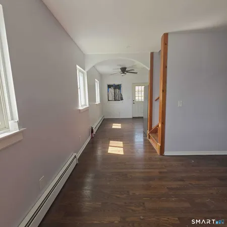 a hallway with wooden floor chandelier and entryway