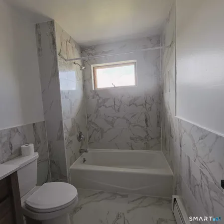 a bathroom with a bathtub toilet and shower