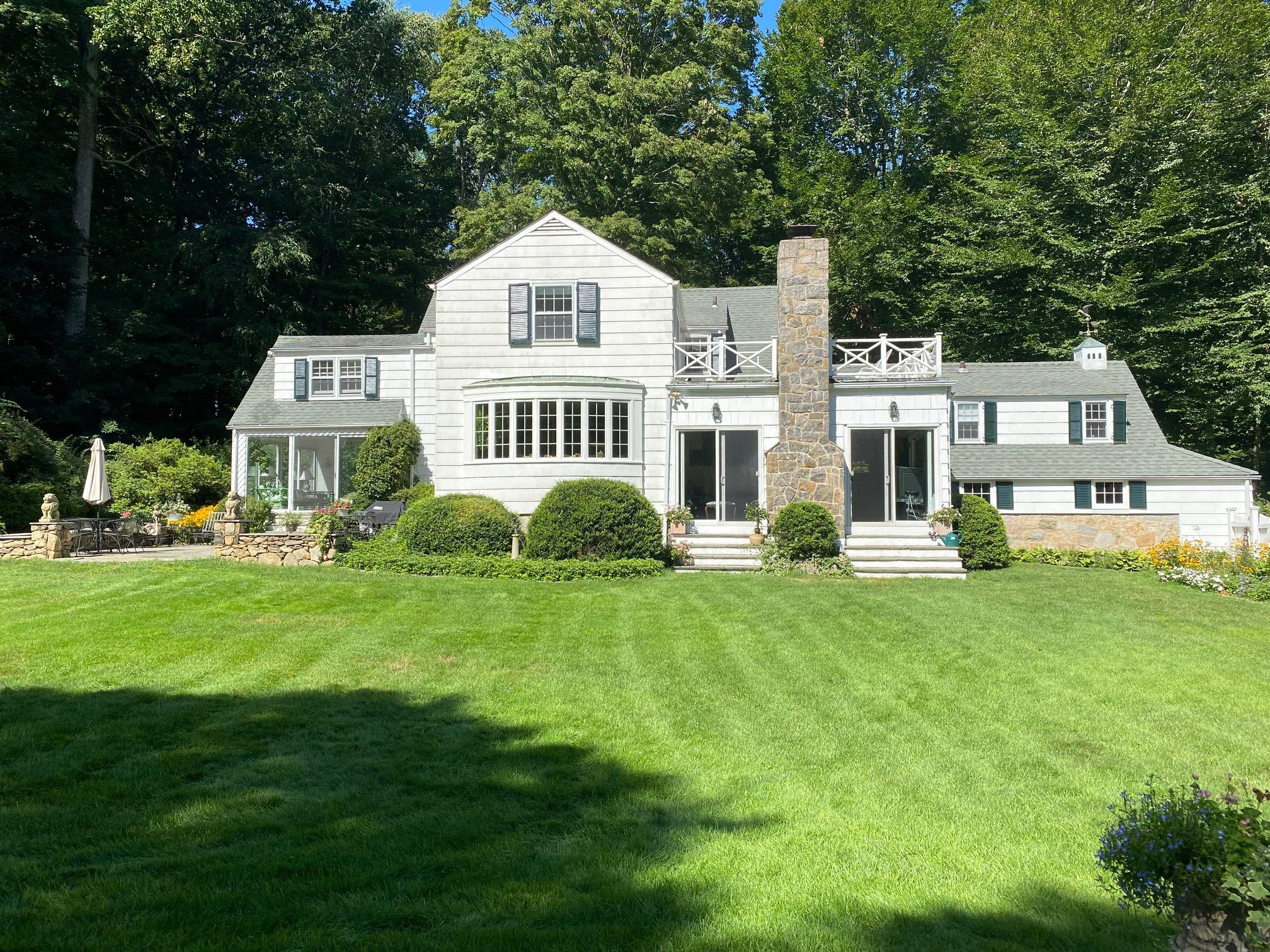 211 Laurel Road New Canaan, CT 06840 - Photo 3 of 47 a front view of a house with a garden