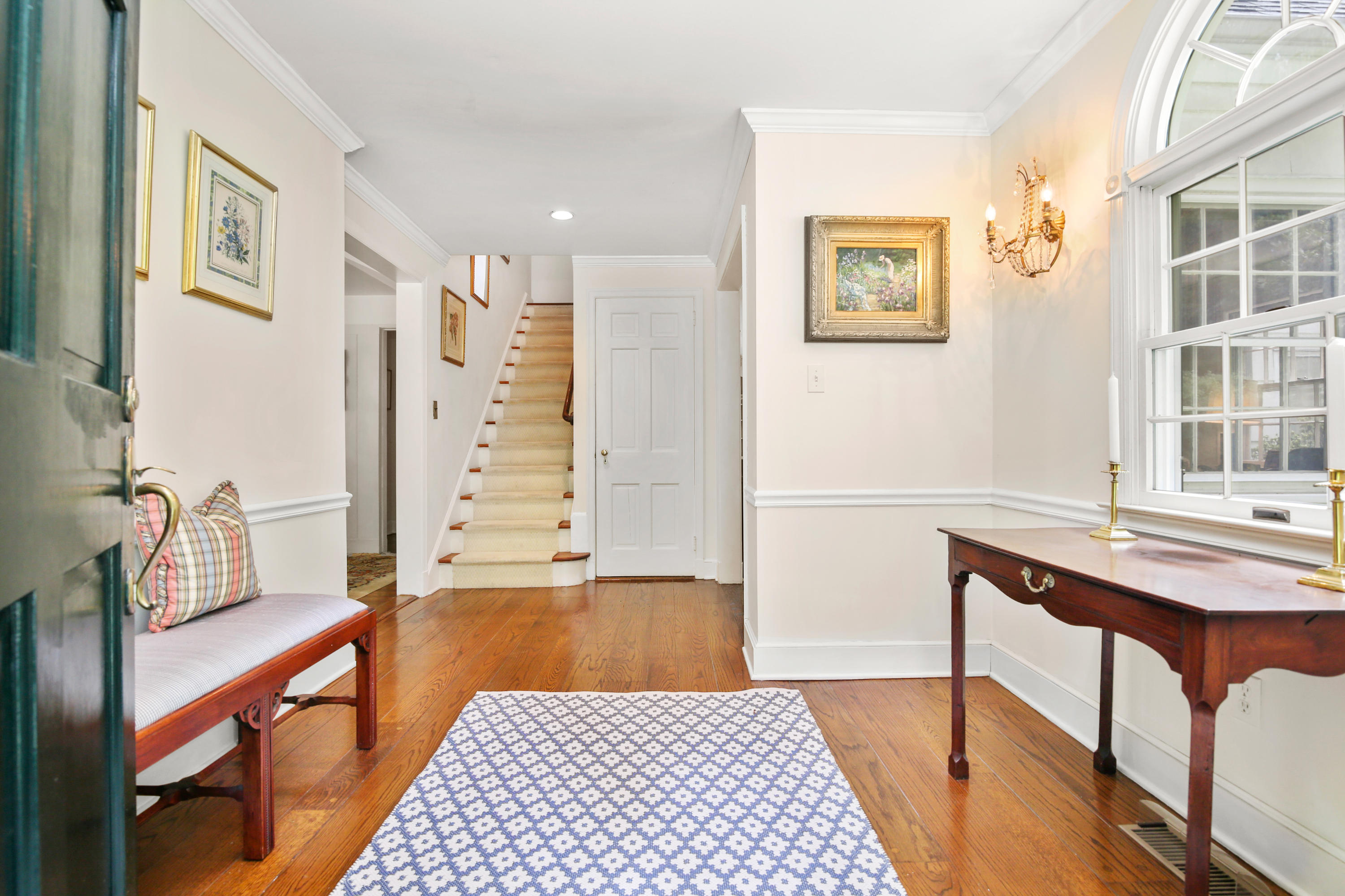 211 Laurel Road New Canaan, CT 06840 - Photo 8 of 47 a hallway with a black white checkered floor and a dining table