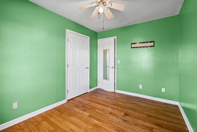 a view of a livingroom with wooden floor and a ceiling fan