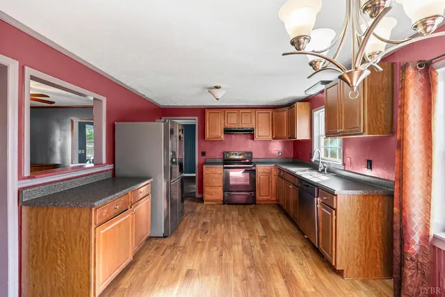 a kitchen with stainless steel appliances granite countertop a stove and a wooden floors