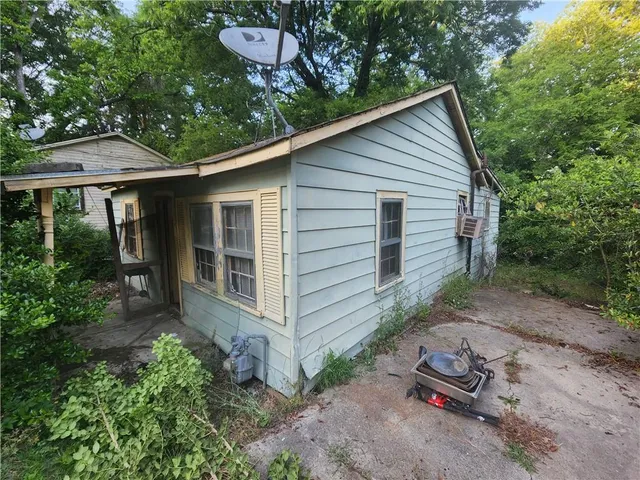 a backyard of a house with plants and outdoor seating