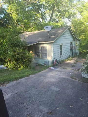 a view of a house with a yard and large tree