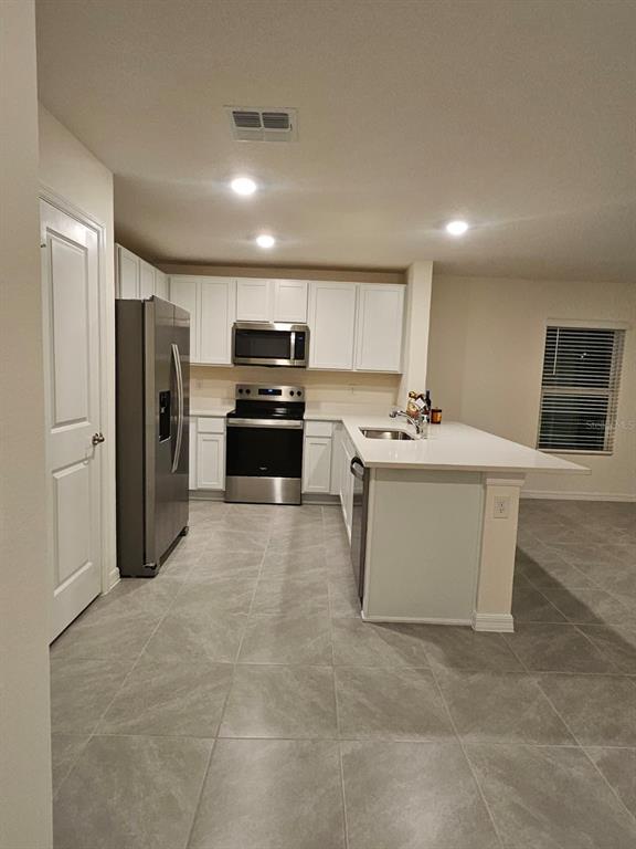 6577 Southwest 81st Loop Ocala, FL 34476 - Photo 4 of 25 a kitchen with stainless steel appliances a refrigerator and a stove top oven