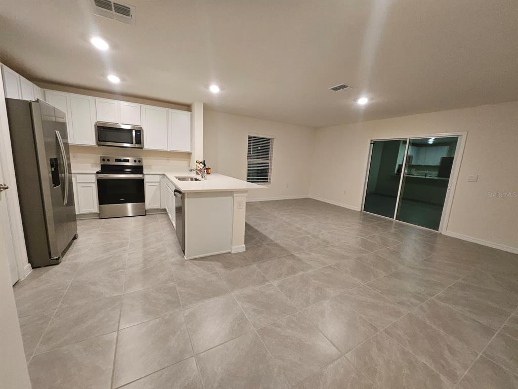 6577 Southwest 81st Loop Ocala, FL 34476 - Photo 5 of 25 a view of kitchen with refrigerator microwave and stove