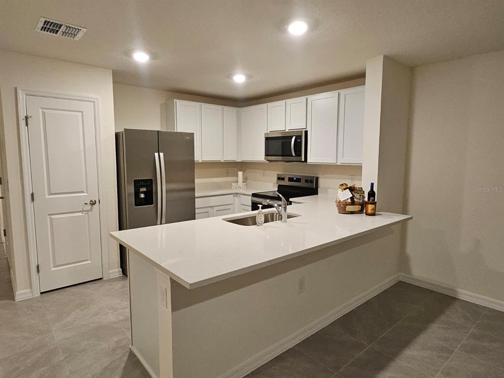 6577 Southwest 81st Loop Ocala, FL 34476 - Photo 6 of 25 a kitchen with stainless steel appliances a refrigerator sink and microwave