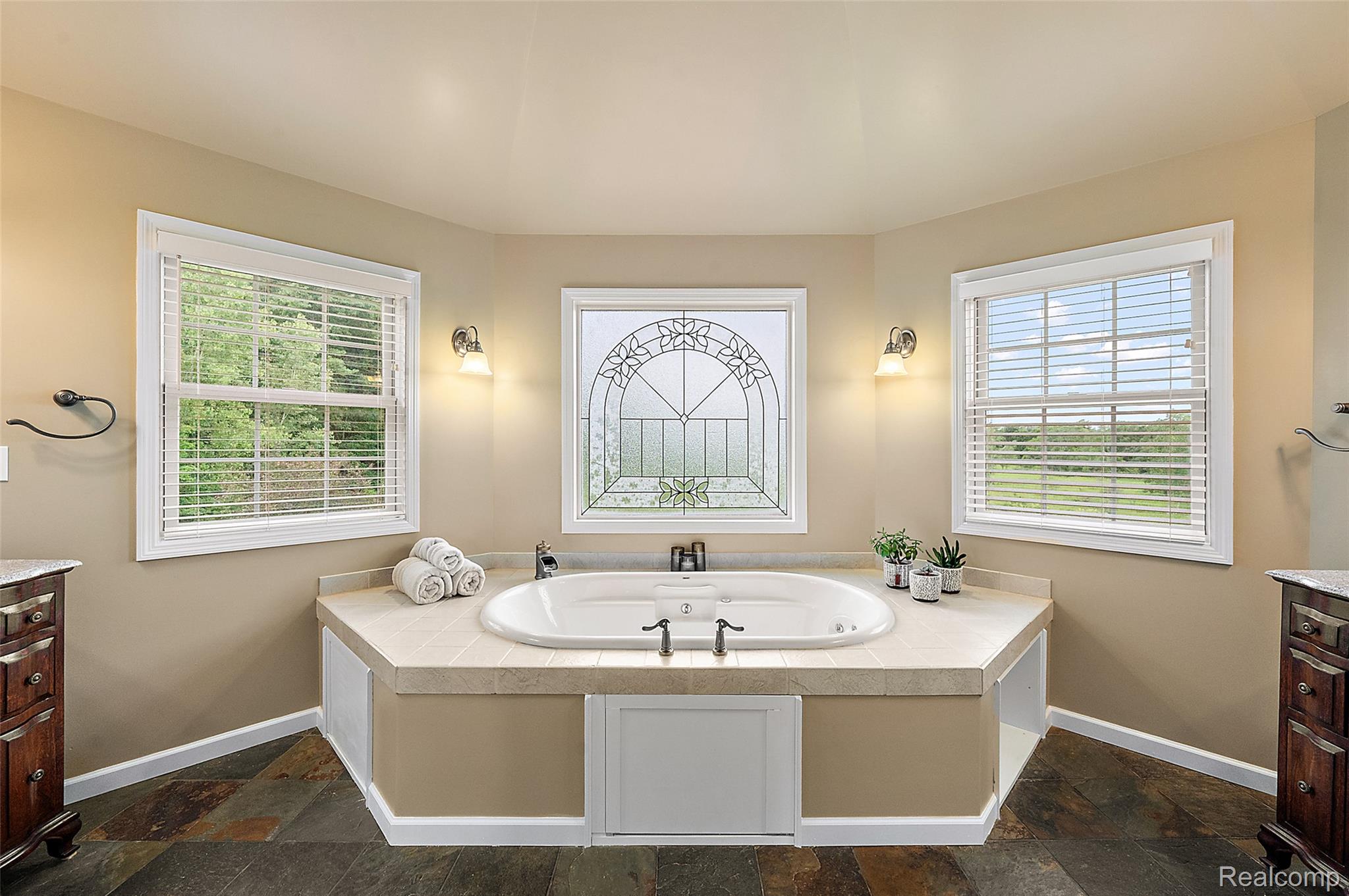 5035 Hidden Ridge Road Metamora, MI 48455 - Photo 34 of 65 Soaking tub with a tiled surround and an ornate frosted window