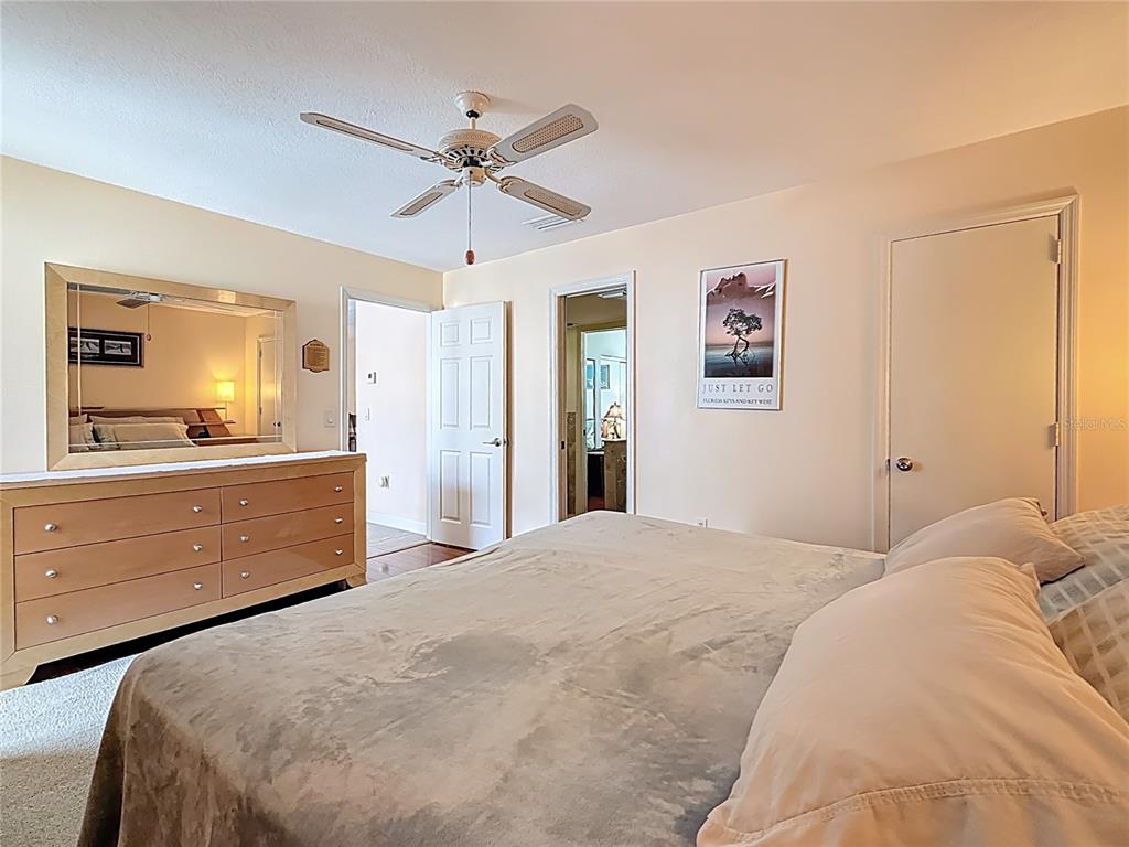 230 Medallion Boulevard, Unit G Madeira Beach, FL 33708 - Photo 18 of 44 a bedroom with a bed and a chandelier
