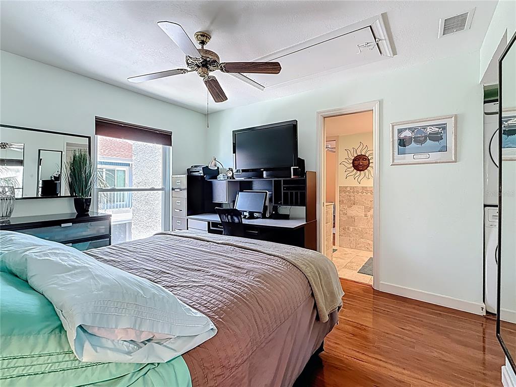 230 Medallion Boulevard, Unit G Madeira Beach, FL 33708 - Photo 19 of 44 a bedroom with a bed and a chandelier