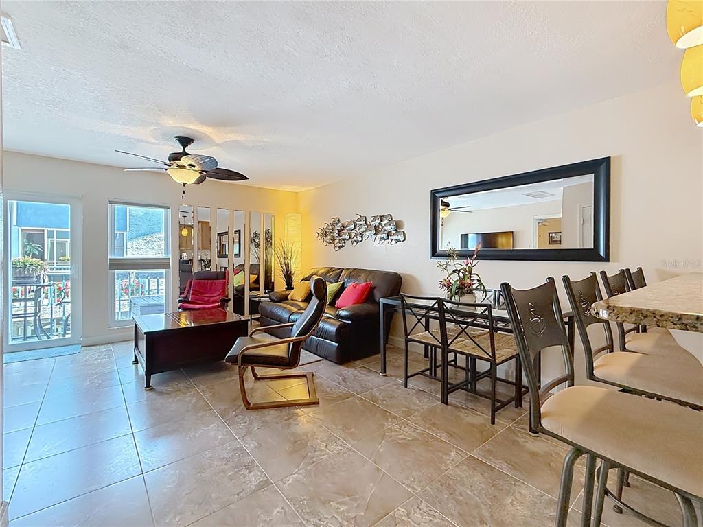 230 Medallion Boulevard, Unit G Madeira Beach, FL 33708 - Photo 10 of 44 a living room with furniture and a flat screen tv